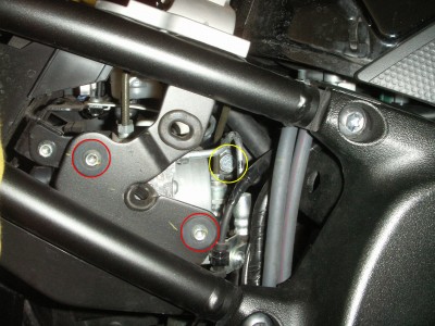 Bei Maschinen mit ABS müssen die Schrauben der ABS-Pumpe (rot) gelöst werden, damit man die Schraube des oberen Auges (gelb) des Federbeins entfernen kann