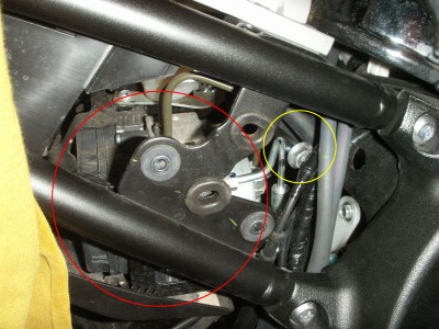 Die gelöste ABS-Pumpe (rot) wird nun so weit zur Seite gedrückt, bis die Schraube des Federbeins (gelb) herausgezogen werden kann